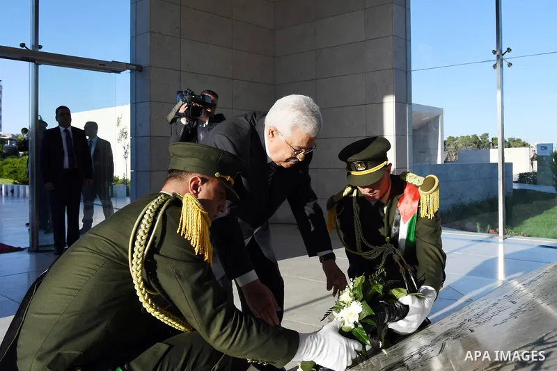 Palestinian President Mahmoud Abbas lays a wreath on the grave of late Palestinian leader Yasser Arafat on the first day of Eid al-Fitr, in the West Bank city of Ramallah on June 25, 2017. Photo by Thaer Ganaim