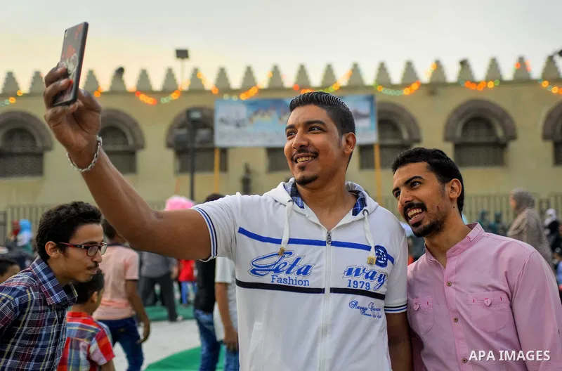 Egyptians take a selfie as they attend the morning prayers for Eid al-Fitr celebrations, which marks the end of the holy fasting month of Ramadan, in Cairo, Egypt, on June 25, 2017. Photo by Amr Sayed