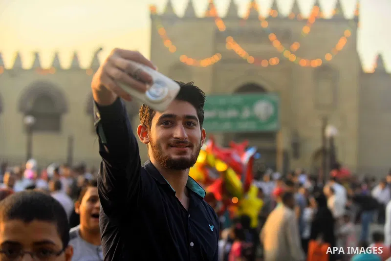 An Egyptian man takes a selfie as he attends the morning prayers for Eid al-Fitr celebrations, which marks the end of the holy fasting month of Ramadan, in Cairo, Egypt, on June 25, 2017. Photo by Amr Sayed