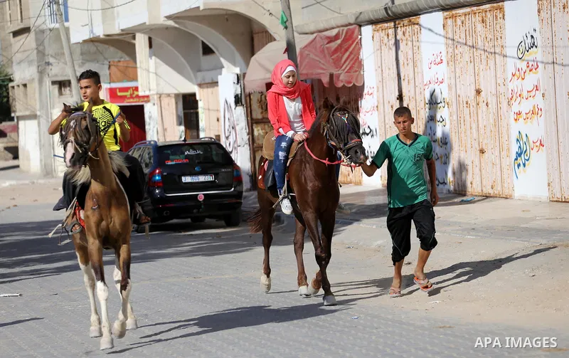 Palestinian children enjoy the first day of Eid al-Fitr holiday which marks the end of the Muslim holy month of Ramadan, in Gaza, on June 25, 2017. Photo by Mohammed Asad