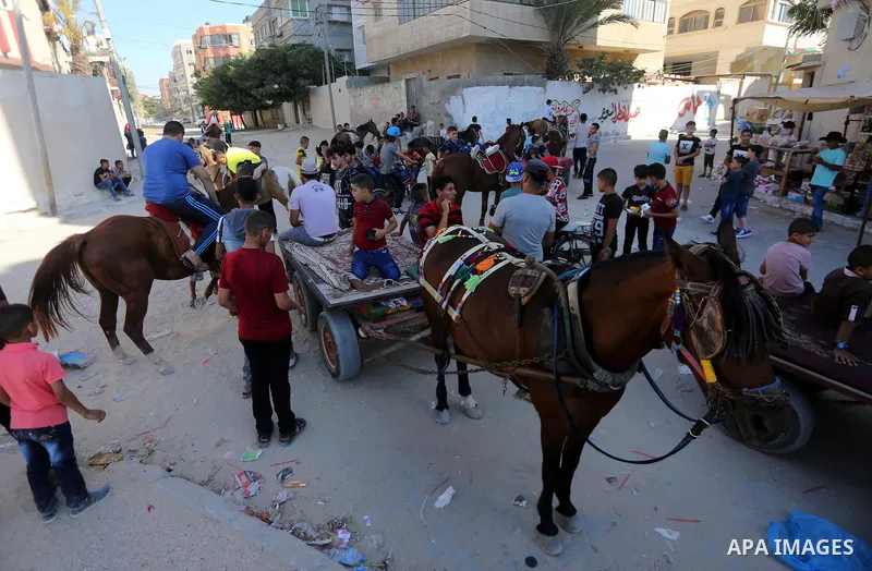Palestinian children enjoy the first day of Eid al-Fitr holiday which marks the end of the Muslim holy month of Ramadan, in Gaza, on June 25, 2017. Photo by Mohammed Asad