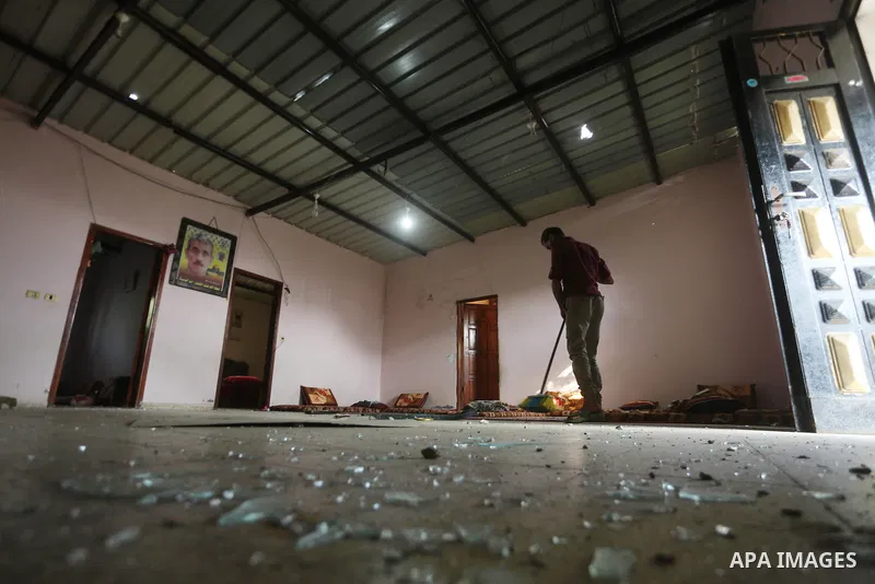A Palestinian man sweeps shattered glass inside his house following an Israeli air strike in Gaza City on June 27, 2017. Israeli airstrikes hit a series of targets in the Hamas-run Gaza Strip overnight June 26, officials...