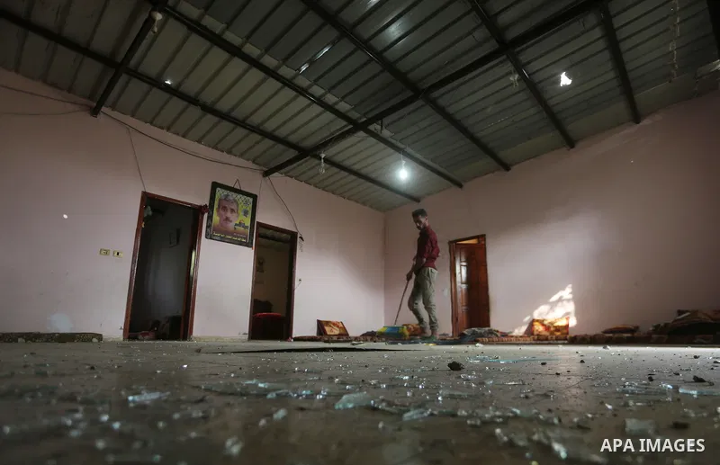 A Palestinian man sweeps shattered glass inside his house following an Israeli air strike in Gaza City on June 27, 2017. Israeli airstrikes hit a series of targets in the Hamas-run Gaza Strip overnight June 26, officials...