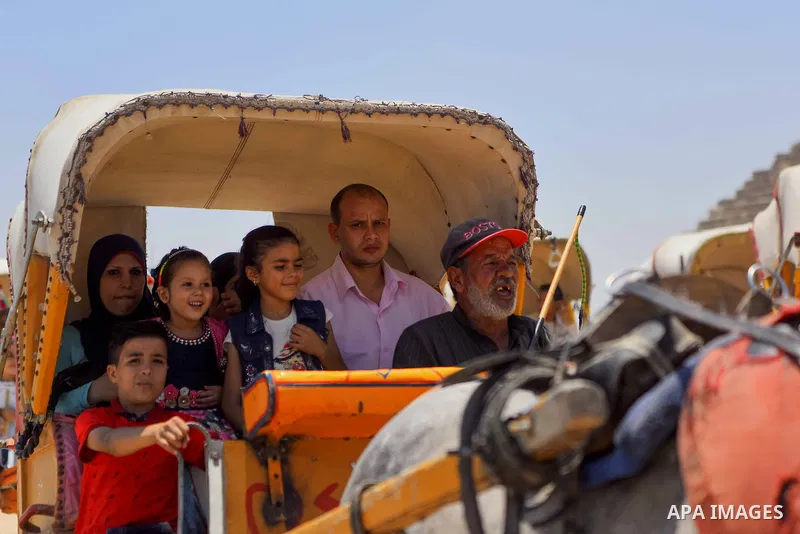 Egyptians ride horse carts in front of the Giza pyramids, on the third day of Eid al-Fitr holiday which marks the end of the Muslim holy month of Ramadan, in Cairo June 27, 2017. Photo by Amr Sayed
