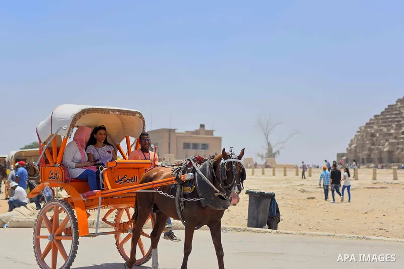 Egyptians ride horse carts in front of the Giza pyramids, on the third day of Eid al-Fitr holiday which marks the end of the Muslim holy month of Ramadan, in Cairo June 27, 2017. Photo by Amr Sayed
