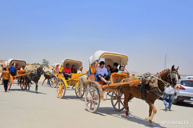 Egyptians ride horse carts in front of the Giza pyramids, on the third day of Eid al-Fitr holiday which marks the end of the Muslim holy month of Ramadan, in Cairo June 27, 2017. Photo by Amr Sayed
