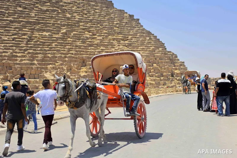 Egyptians ride horse carts in front of the Giza pyramids, on the third day of Eid al-Fitr holiday which marks the end of the Muslim holy month of Ramadan, in Cairo June 27, 2017. Photo by Amr Sayed