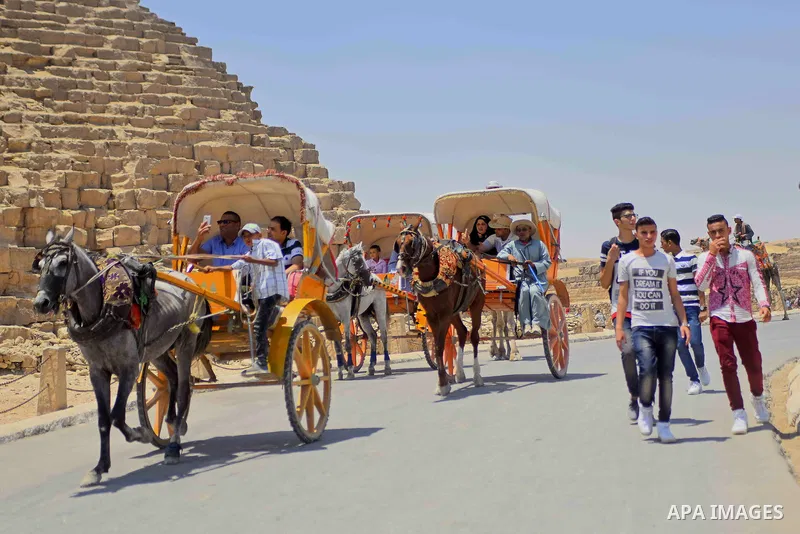 Egyptians ride horse carts in front of the Giza pyramids, on the third day of Eid al-Fitr holiday which marks the end of the Muslim holy month of Ramadan, in Cairo June 27, 2017. Photo by Amr Sayed