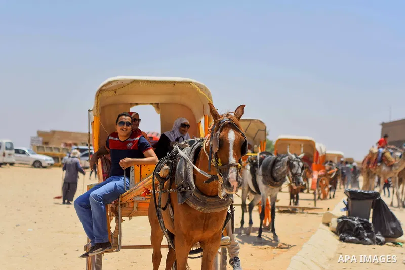 Egyptians ride horse carts in front of the Giza pyramids, on the third day of Eid al-Fitr holiday which marks the end of the Muslim holy month of Ramadan, in Cairo June 27, 2017. Photo by Amr Sayed