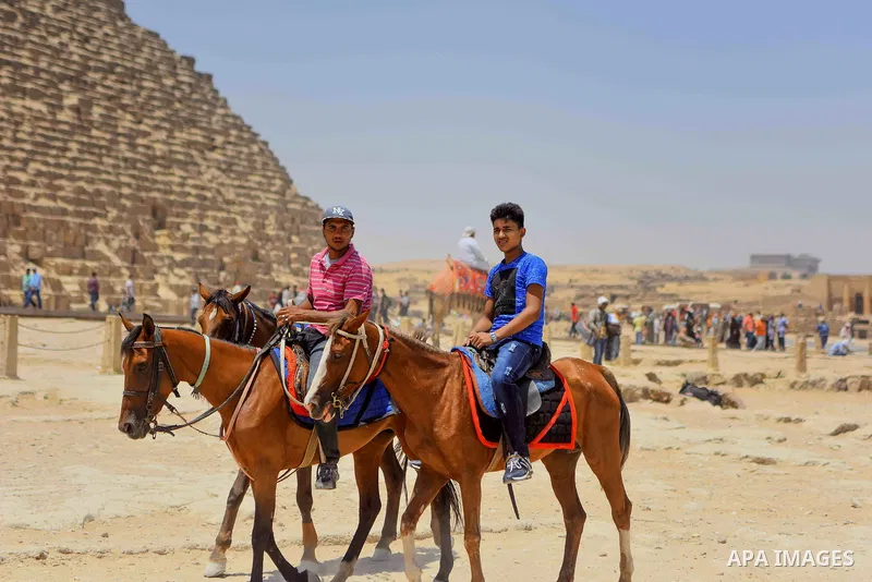Egyptians ride horses in front of the Giza pyramids, on the third day of Eid al-Fitr holiday which marks the end of the Muslim holy month of Ramadan, in Cairo June 27, 2017. Photo by Amr Sayed