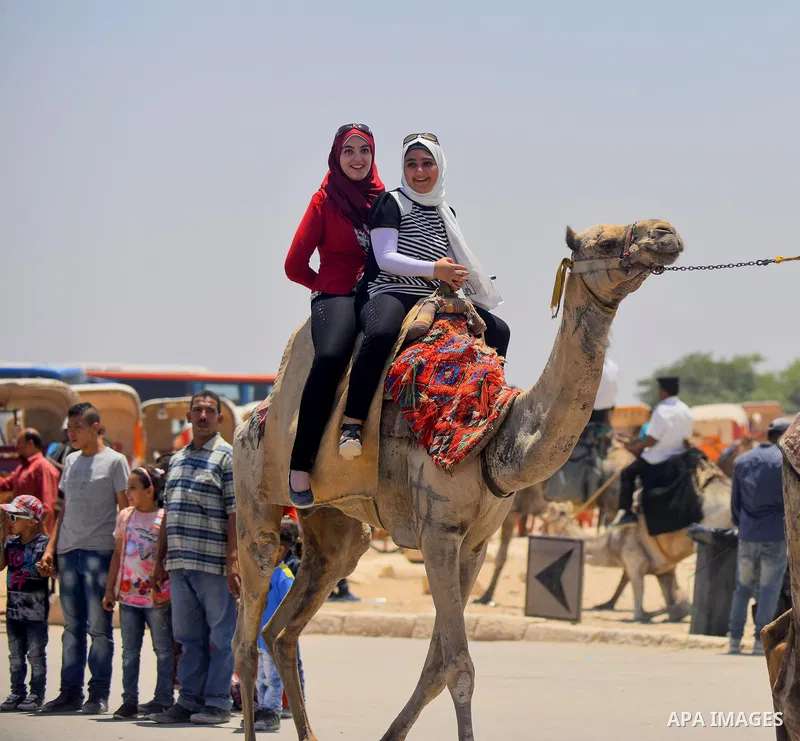 Egyptian girls ride camels in front of the Giza pyramids, on the third day of Eid al-Fitr holiday which marks the end of the Muslim holy month of Ramadan, in Cairo June 27, 2017. Photo by Amr Sayed