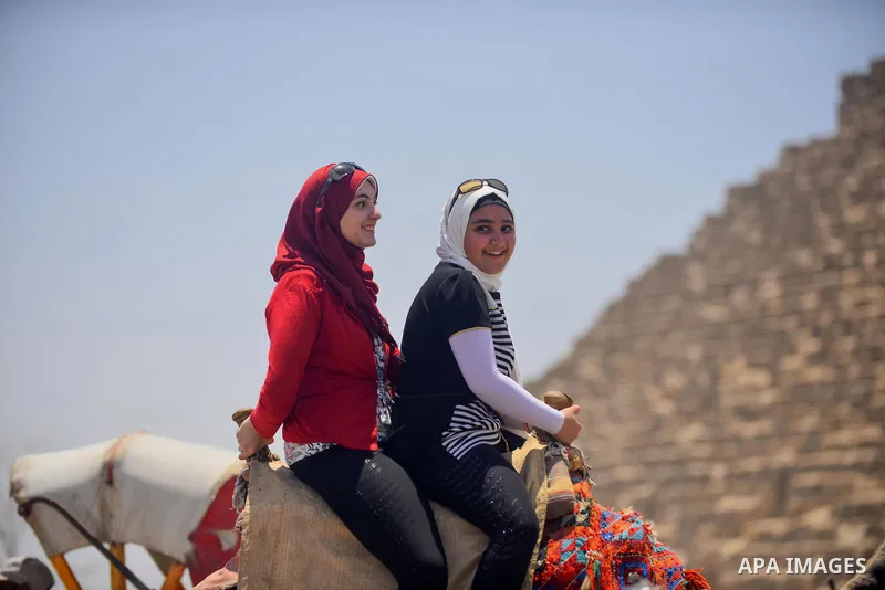 Egyptian girls ride camels in front of the Giza pyramids, on the third day of Eid al-Fitr holiday which marks the end of the Muslim holy month of Ramadan, in Cairo June 27, 2017. Photo by Amr Sayed