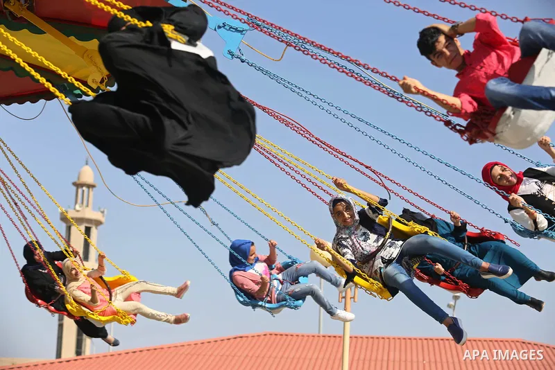 Palestinians take a ride at an amusement park on the third day of Eid al-Fitr holiday which marks the end of the Muslim holy month of Ramadan, in Gaza City on June 27, 2017. Photo by Ashraf Amra