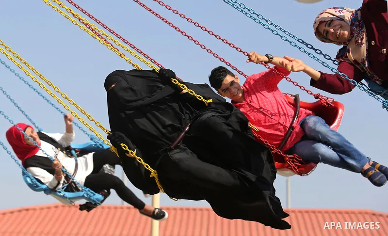 Palestinians take a ride at an amusement park on the third day of Eid al-Fitr holiday which marks the end of the Muslim holy month of Ramadan, in Gaza City on June 27, 2017. Photo by Ashraf Amra