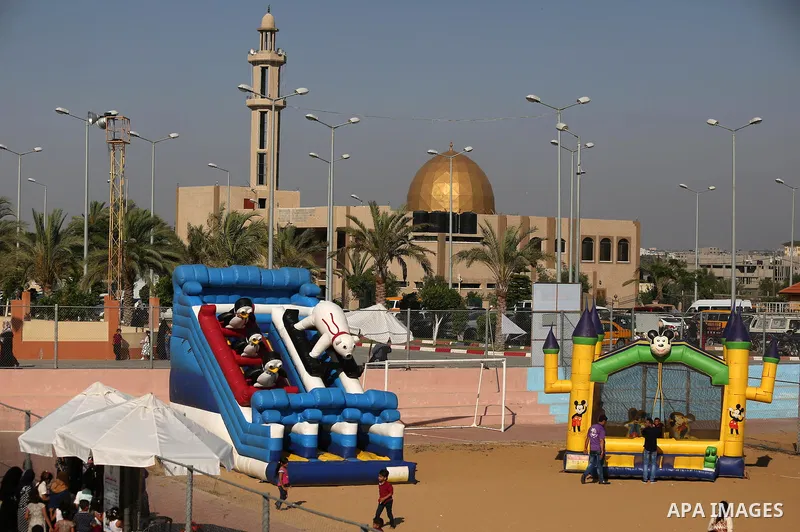 Palestinian children play at an amusement park on the third day of Eid al-Fitr holiday which marks the end of the Muslim holy month of Ramadan, in Gaza City on June 27, 2017. Photo by Ashraf Amra