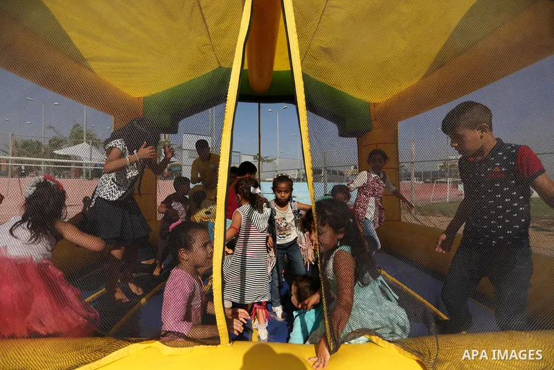 Palestinian children play at an amusement park on the third day of Eid al-Fitr holiday which marks the end of the Muslim holy month of Ramadan, in Gaza City on June 27, 2017. Photo by Ashraf Amra