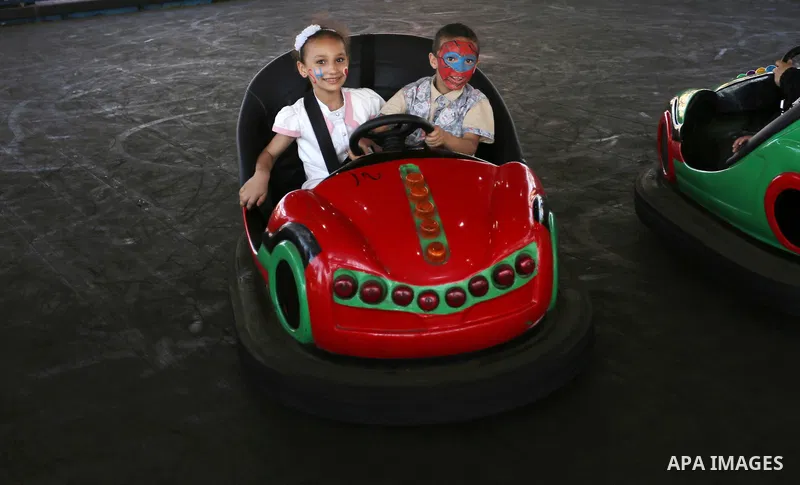 Palestinian children ride bumper car at an amusement park on the third day of Eid al-Fitr holiday which marks the end of the Muslim holy month of Ramadan, in Gaza City on June 27, 2017. Photo by Ashraf Amra