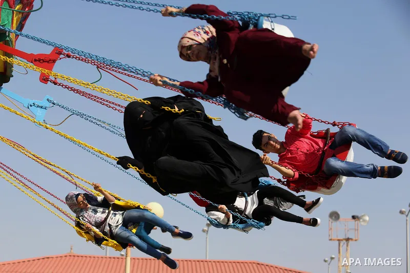 Palestinians take a ride at an amusement park on the third day of Eid al-Fitr holiday which marks the end of the Muslim holy month of Ramadan, in Gaza City on June 27, 2017. Photo by Ashraf Amra