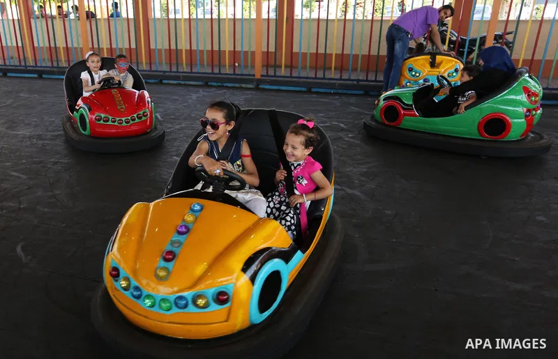 Palestinian children ride bumper car at an amusement park on the third day of Eid al-Fitr holiday which marks the end of the Muslim holy month of Ramadan, in Gaza City on June 27, 2017. Photo by Ashraf Amra
