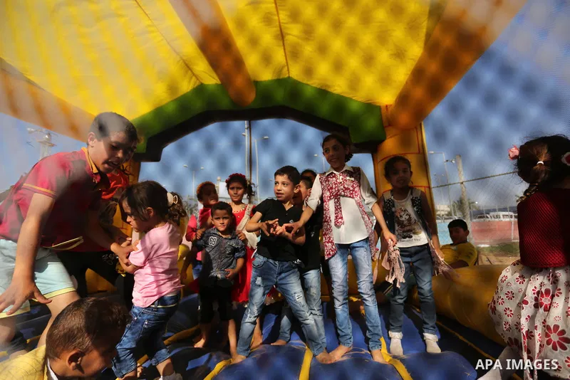 Palestinian children play at an amusement park on the third day of Eid al-Fitr holiday which marks the end of the Muslim holy month of Ramadan, in Gaza City on June 27, 2017. Photo by Ashraf Amra