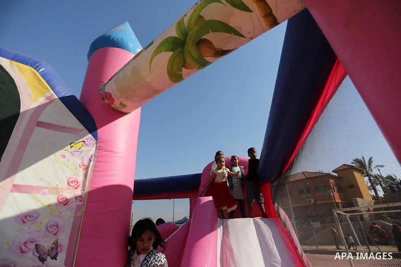 Palestinian children play at an amusement park on the third day of Eid al-Fitr holiday which marks the end of the Muslim holy month of Ramadan, in Gaza City on June 27, 2017. Photo by Ashraf Amra