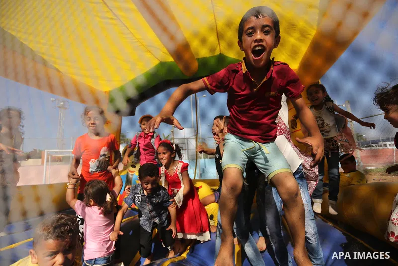 Palestinian children play at an amusement park on the third day of Eid al-Fitr holiday which marks the end of the Muslim holy month of Ramadan, in Gaza City on June 27, 2017. Photo by Ashraf Amra