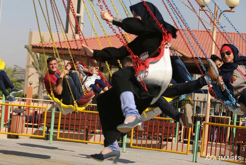 Palestinians take a ride at an amusement park on the third day of Eid al-Fitr holiday which marks the end of the Muslim holy month of Ramadan, in Gaza City on June 27, 2017. Photo by Ashraf Amra