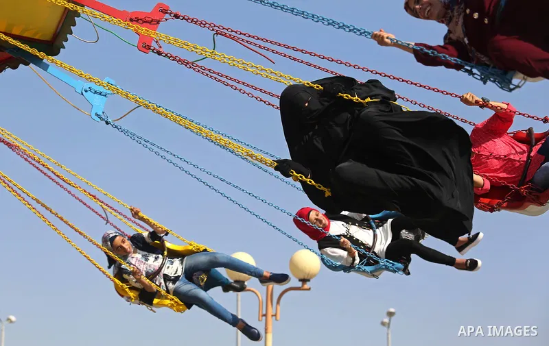 Palestinians take a ride at an amusement park on the third day of Eid al-Fitr holiday which marks the end of the Muslim holy month of Ramadan, in Gaza City on June 27, 2017. Photo by Ashraf Amra