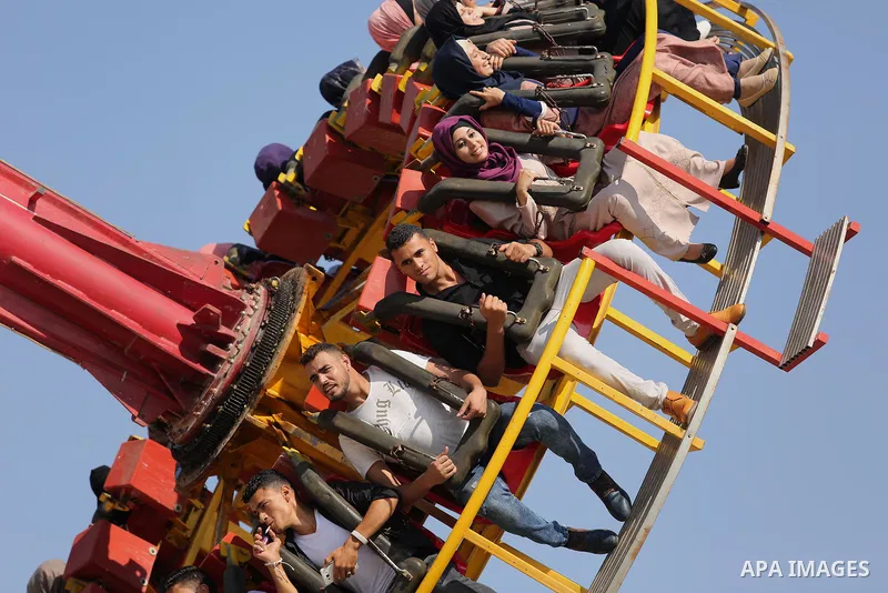 Palestinians take a ride at an amusement park on the third day of Eid al-Fitr holiday which marks the end of the Muslim holy month of Ramadan, in Gaza City on June 27, 2017. Photo by Ashraf Amra