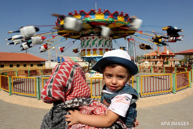 Palestinians take a ride at an amusement park on the third day of Eid al-Fitr holiday which marks the end of the Muslim holy month of Ramadan, in Gaza City on June 27, 2017. Photo by Ashraf Amra