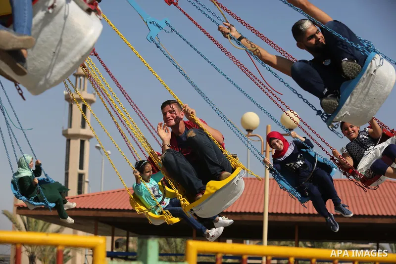 Palestinians take a ride at an amusement park on the third day of Eid al-Fitr holiday which marks the end of the Muslim holy month of Ramadan, in Gaza City on June 27, 2017. Photo by Ashraf Amra