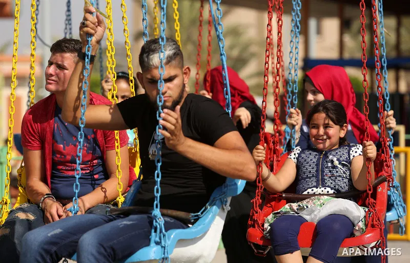 Palestinians take a ride at an amusement park on the third day of Eid al-Fitr holiday which marks the end of the Muslim holy month of Ramadan, in Gaza City on June 27, 2017. Photo by Ashraf Amra