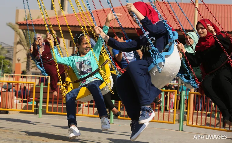Palestinians take a ride at an amusement park on the third day of Eid al-Fitr holiday which marks the end of the Muslim holy month of Ramadan, in Gaza City on June 27, 2017. Photo by Ashraf Amra