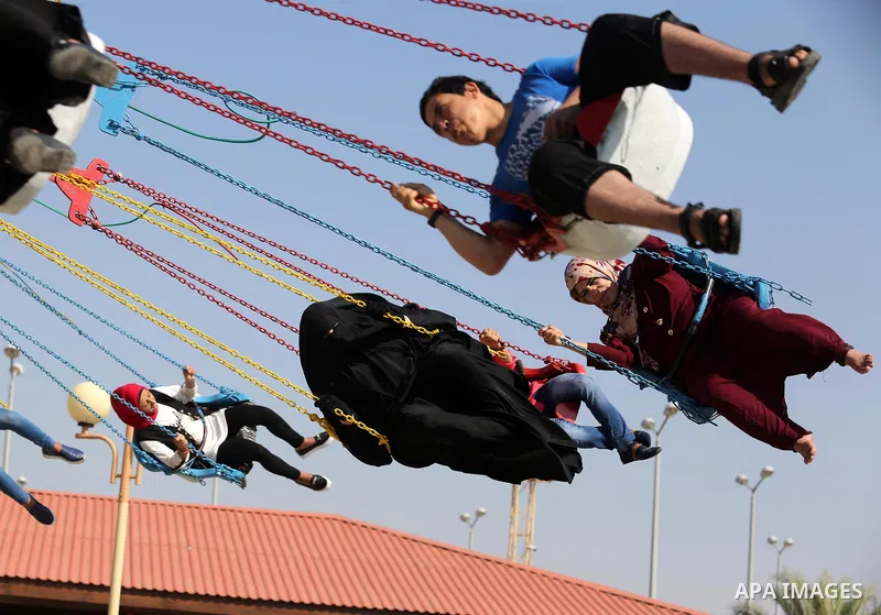 Palestinians take a ride at an amusement park on the third day of Eid al-Fitr holiday which marks the end of the Muslim holy month of Ramadan, in Gaza City on June 27, 2017. Photo by Ashraf Amra