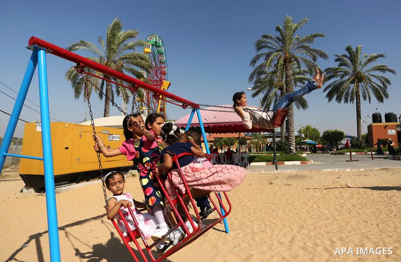 Palestinians take a ride at an amusement park on the third day of Eid al-Fitr holiday which marks the end of the Muslim holy month of Ramadan, in Gaza City on June 27, 2017. Photo by Ashraf Amra