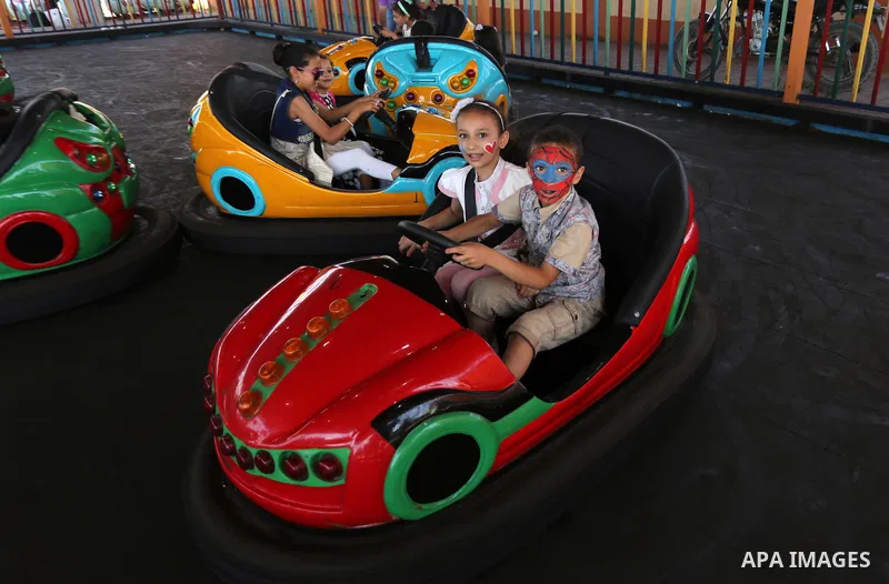 Palestinian children ride bumper car at an amusement park on the third day of Eid al-Fitr holiday which marks the end of the Muslim holy month of Ramadan, in Gaza City on June 27, 2017. Photo by Ashraf Amra