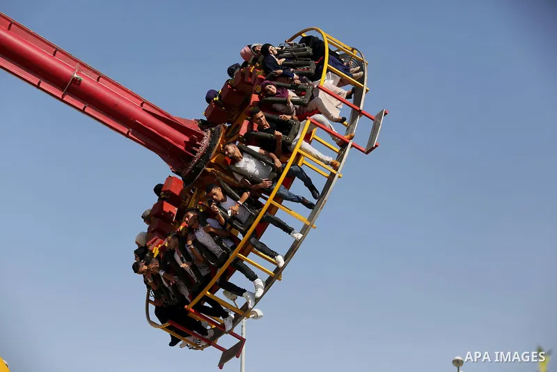 Palestinians take a ride at an amusement park on the third day of Eid al-Fitr holiday which marks the end of the Muslim holy month of Ramadan, in Gaza City on June 27, 2017. Photo by Ashraf Amra