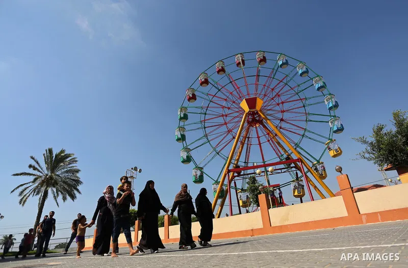 Palestinians take a ride at an amusement park on the third day of Eid al-Fitr holiday which marks the end of the Muslim holy month of Ramadan, in Gaza City on June 27, 2017. Photo by Ashraf Amra