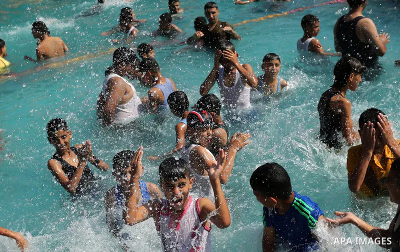 Palestinian children swim in a pool at an amusement park on the third day of Eid al-Fitr holiday which marks the end of the Muslim holy month of Ramadan, in Gaza City on June 27, 2017. Photo by Ashraf Amra
