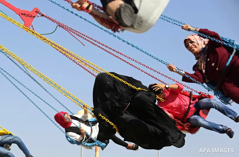 Palestinians take a ride at an amusement park on the third day of Eid al-Fitr holiday which marks the end of the Muslim holy month of Ramadan, in Gaza City on June 27, 2017. Photo by Ashraf Amra