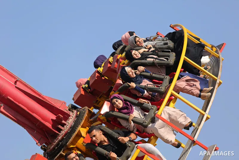 Palestinians take a ride at an amusement park on the third day of Eid al-Fitr holiday which marks the end of the Muslim holy month of Ramadan, in Gaza City on June 27, 2017. Photo by Ashraf Amra