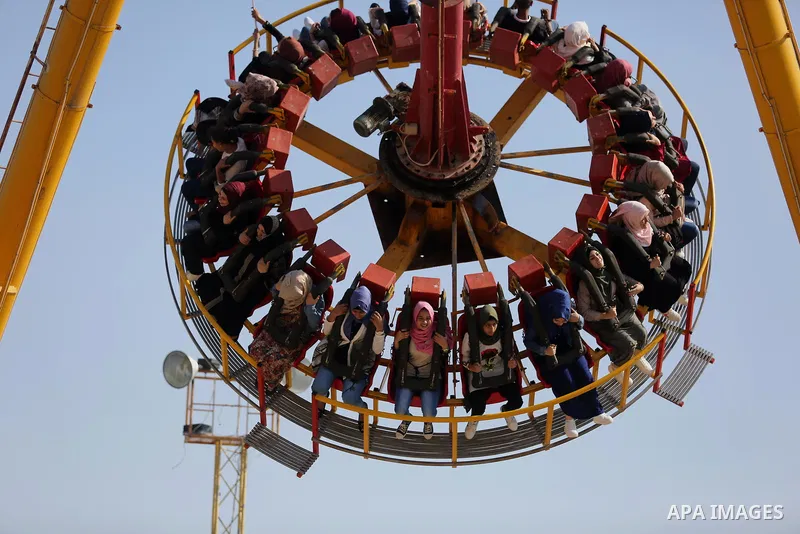 Palestinians take a ride at an amusement park on the third day of Eid al-Fitr holiday which marks the end of the Muslim holy month of Ramadan, in Gaza City on June 27, 2017. Photo by Ashraf Amra