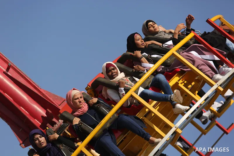 Palestinians take a ride at an amusement park on the third day of Eid al-Fitr holiday which marks the end of the Muslim holy month of Ramadan, in Gaza City on June 27, 2017. Photo by Ashraf Amra