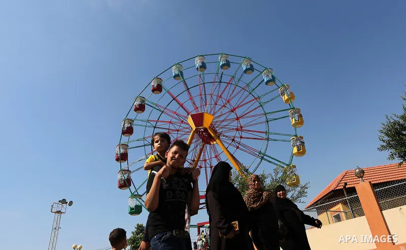 Palestinians take a ride at an amusement park on the third day of Eid al-Fitr holiday which marks the end of the Muslim holy month of Ramadan, in Gaza City on June 27, 2017. Photo by Ashraf Amra