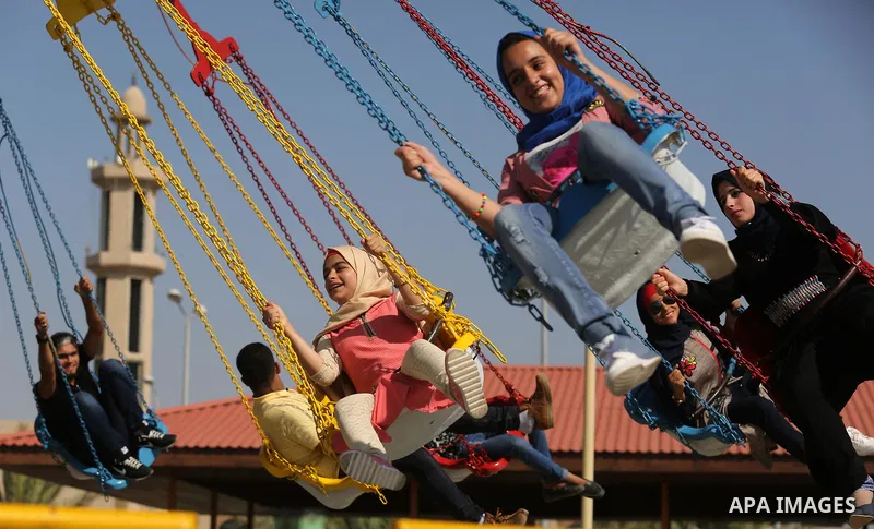 Palestinians take a ride at an amusement park on the third day of Eid al-Fitr holiday which marks the end of the Muslim holy month of Ramadan, in Gaza City on June 27, 2017. Photo by Ashraf Amra
