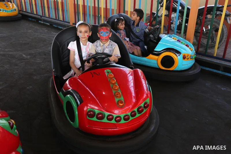 Palestinian children ride bumper car at an amusement park on the third day of Eid al-Fitr holiday which marks the end of the Muslim holy month of Ramadan, in Gaza City on June 27, 2017. Photo by Ashraf Amra