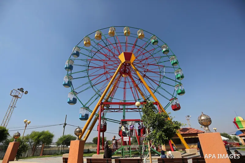 Palestinians take a ride at an amusement park on the third day of Eid al-Fitr holiday which marks the end of the Muslim holy month of Ramadan, in Gaza City on June 27, 2017. Photo by Ashraf Amra