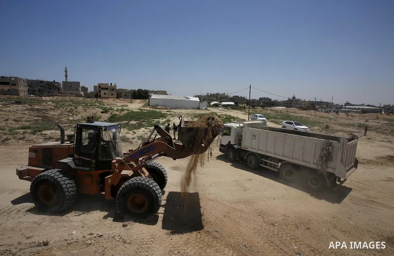 Palestinian bulldozers clear an area as Hamas begins creating a large buffer zone on the border with Egypt in the southern Gaza strip town of Rafah, on June 28, 2017. The buffer zone is expected to extend for a length of...