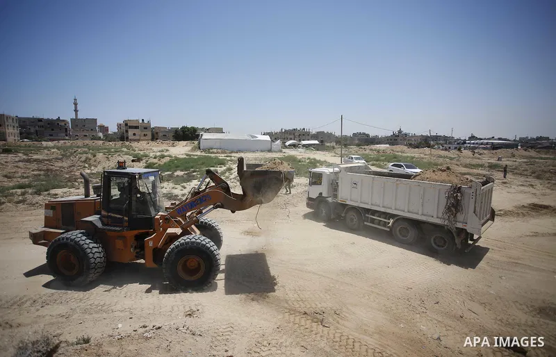 Palestinian bulldozers clear an area as Hamas begins creating a large buffer zone on the border with Egypt in the southern Gaza strip town of Rafah, on June 28, 2017. The buffer zone is expected to extend for a length of...