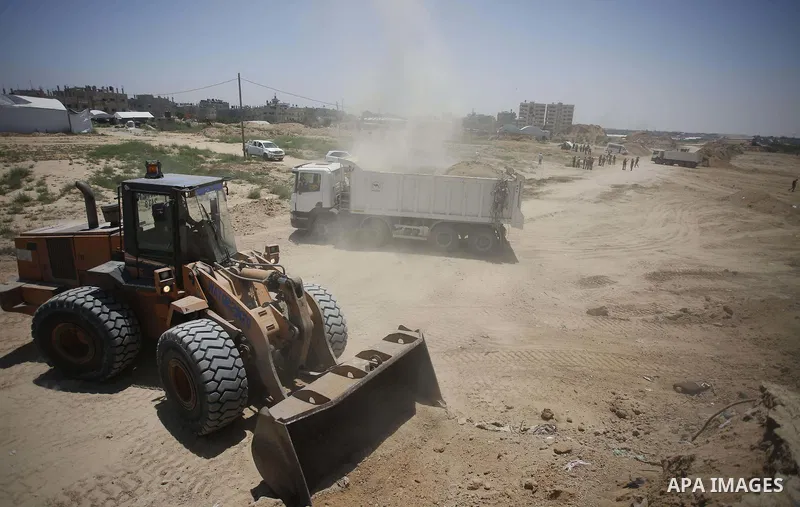 Palestinian bulldozers clear an area as Hamas begins creating a large buffer zone on the border with Egypt in the southern Gaza strip town of Rafah, on June 28, 2017. The buffer zone is expected to extend for a length of...